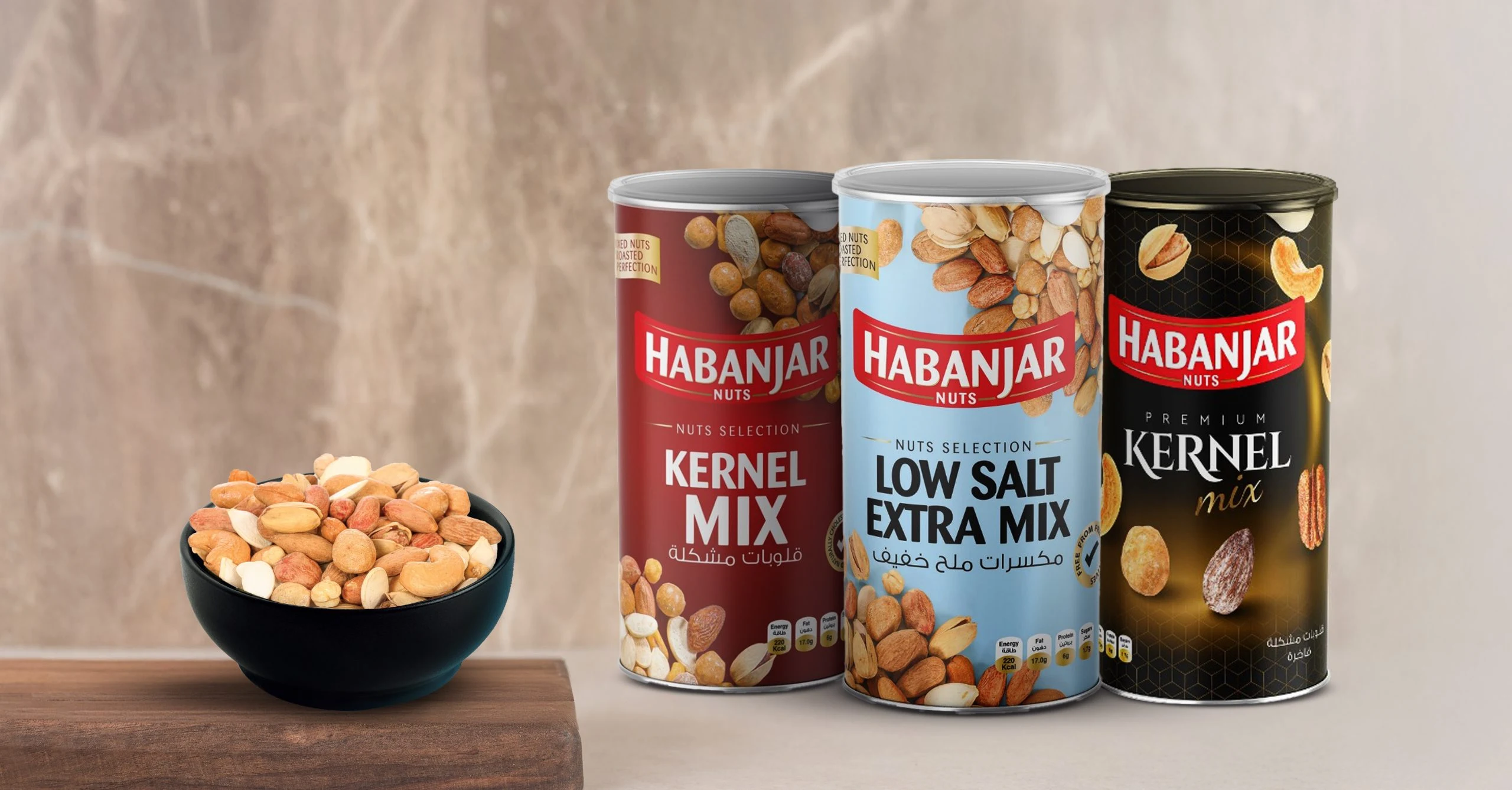 Habanjar Kernel Mix, Low Salt Extra Mix and Premium Kernel Mix cans beside a bowl of nuts